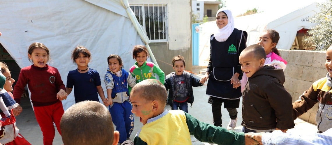 Syrian refugees play with classmates