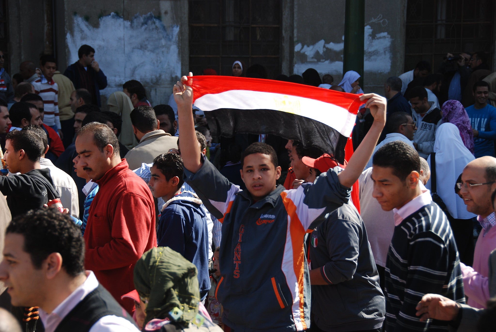 A young Egyptian protester holding an Egyptian flag, Cairo, Egypt