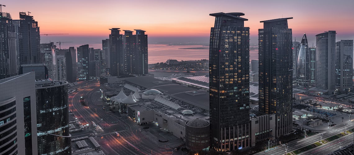 An aerial view of West Bay, Doha City, Qatar, appears at sunset.