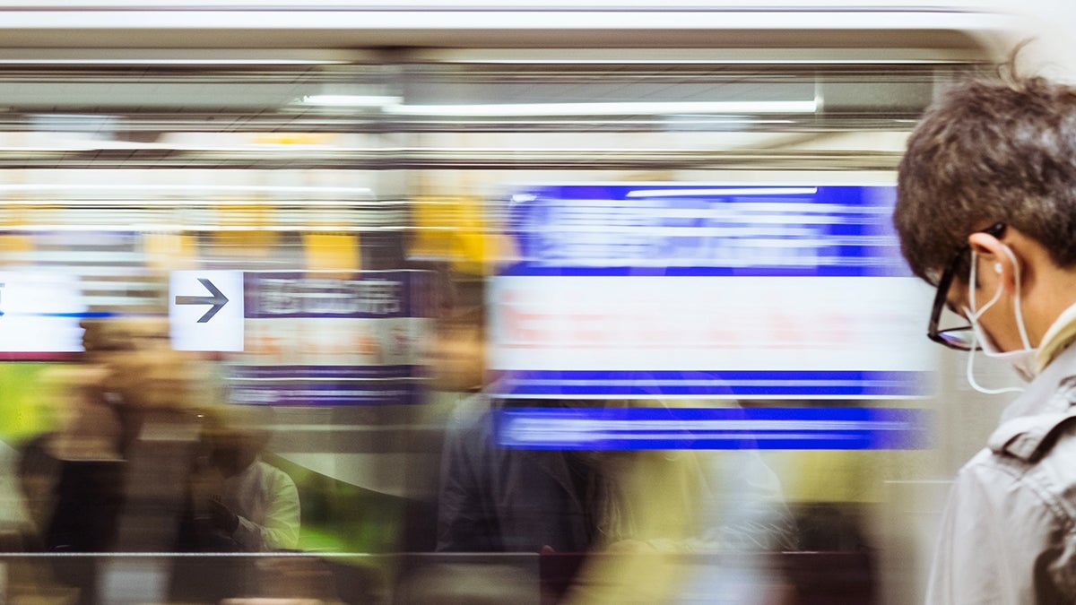 A man with a face wask waits to board a train in Tokyo, Japan. Photo: Carina Sze/Unsplash